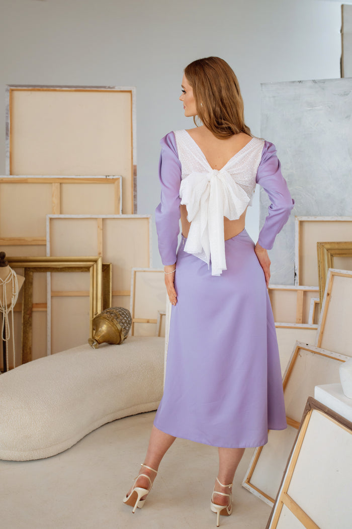 Back view of the dress highlighting the large white lace cotton bow, with a romantic and artistic touch.