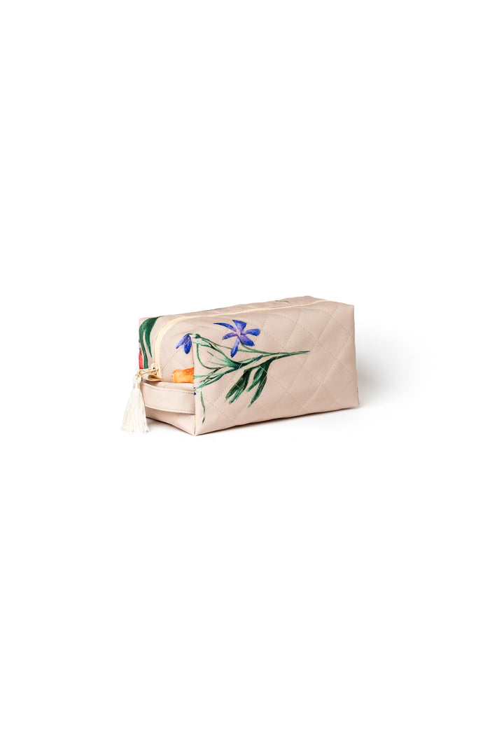 Small beige floral cosmetic bag with beige zipper and tassel detail for makeup, skincare, and travel accessories