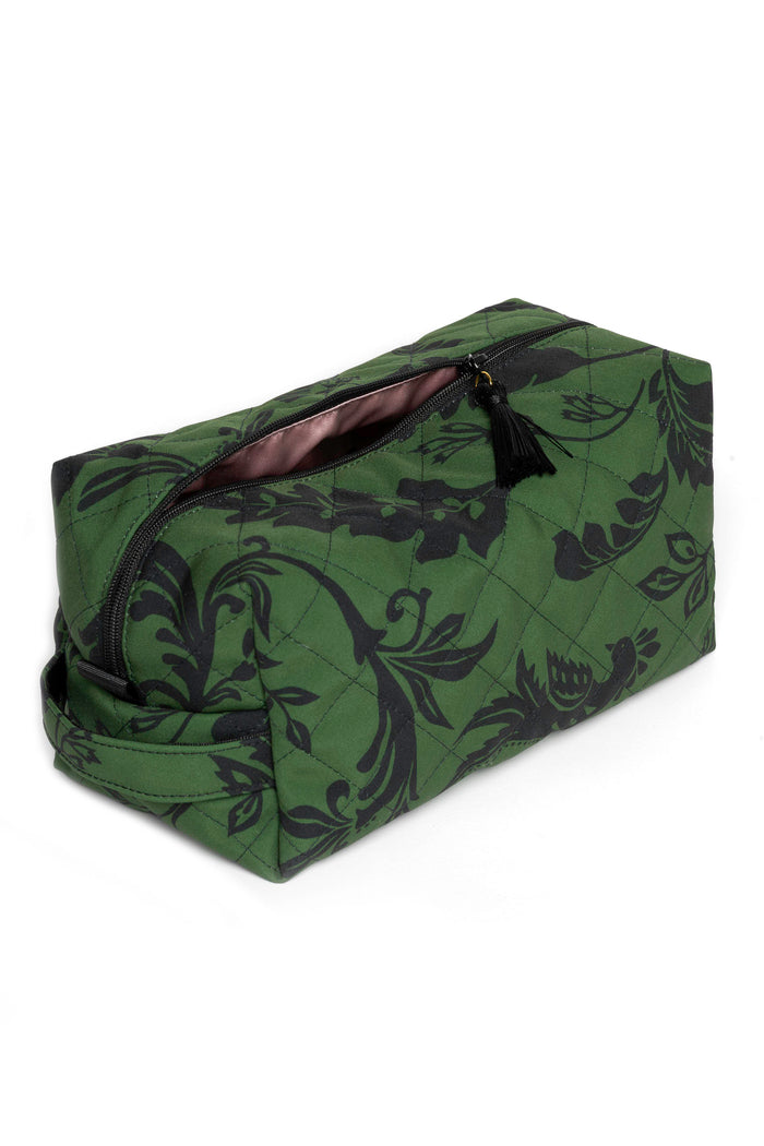 Forest Flower makeup bag featuring a green background with black floral print and decorative tassels