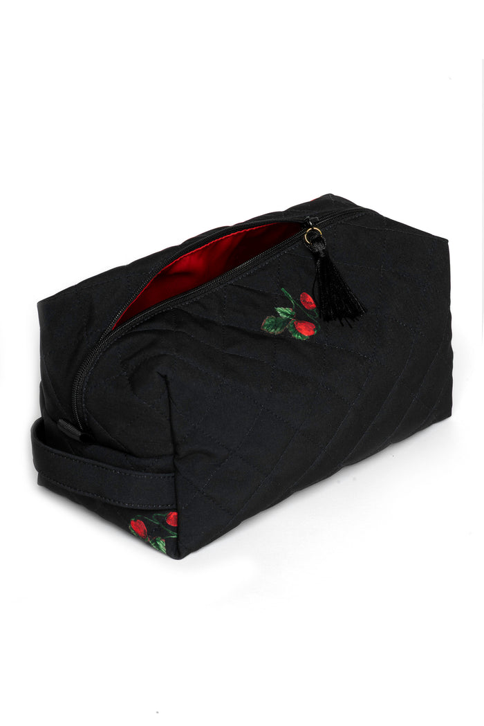 Large black travel makeup bag with strawberry print opened to show red lining and spacious cosmetic storage compartment