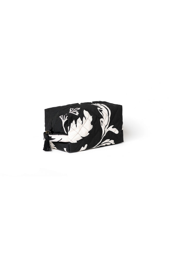 Large black cosmetic bag with white floral print, black zipper closure, and decorative tassel detail