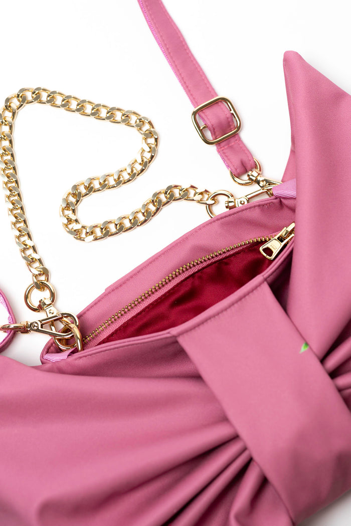 Pink handbag with gold chain strap on a white background by rainsisters