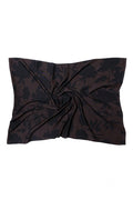 A brown scarf of wool and silk fabric with a subtle tonal floral pattern, styled with a central twist on a plain white background.