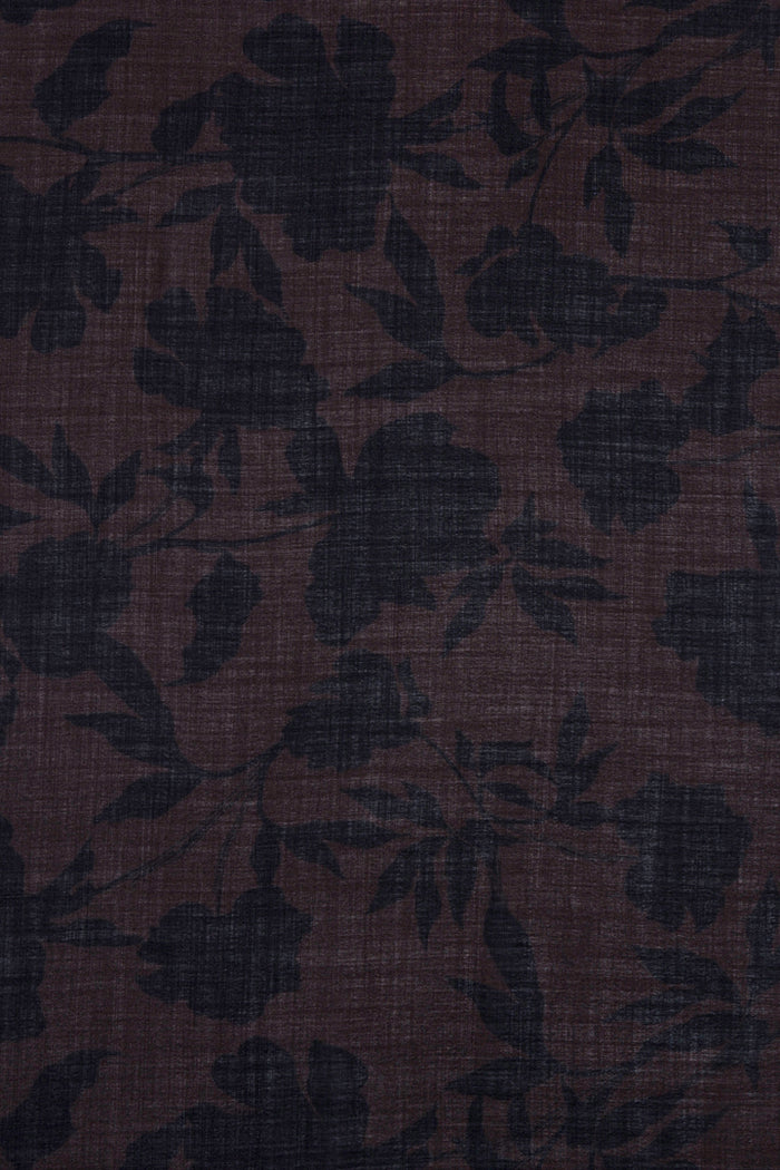 Dark brown fabric with a subtle floral pattern and visible woven texture.