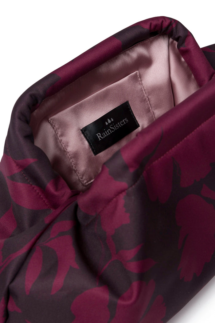 Women's burgundy floral clutch bag featuring a rich wine-toned floral print, structured silhouette, secure frame closure, and elegant ashy pink lining.