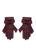 A pair of burgundy leather gloves with wide wristbands and large bow details, displayed flat against a plain white background.