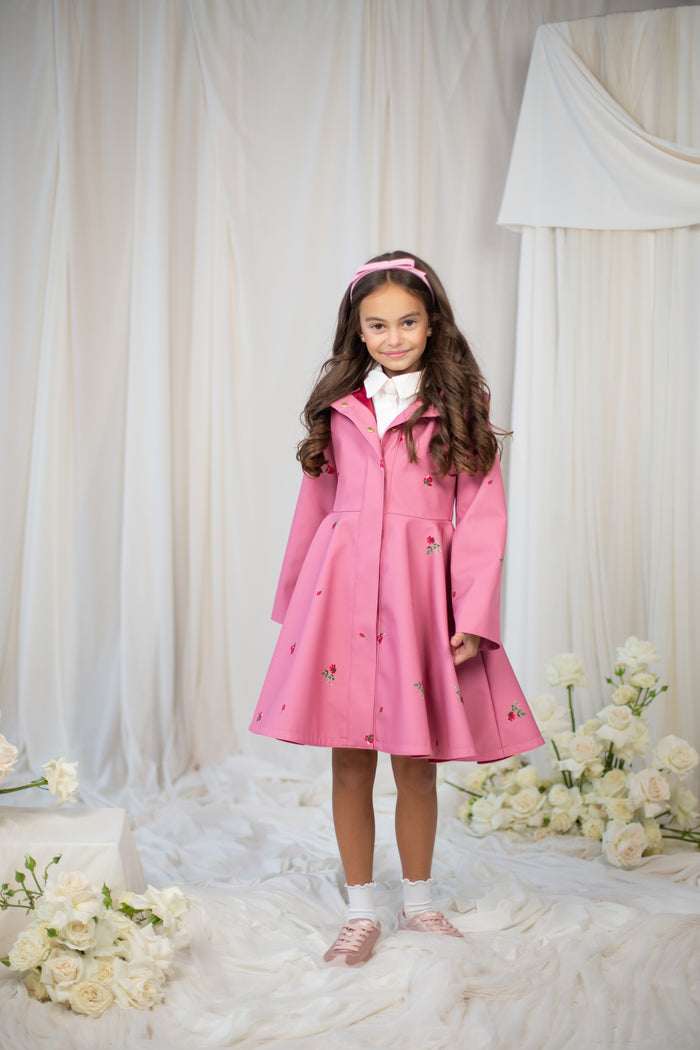 Young girl wearing a pink coat with a hood
