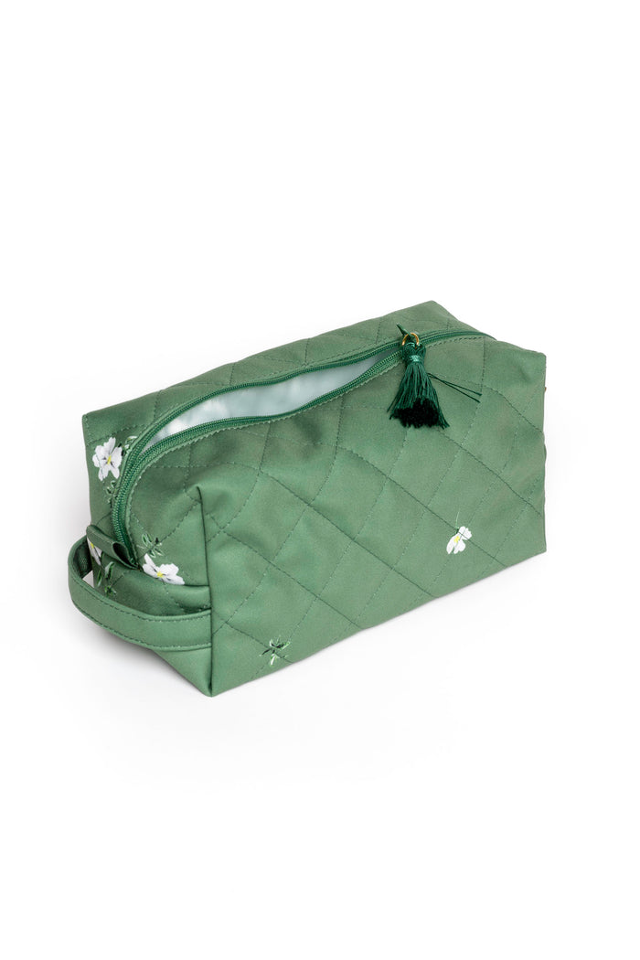 Women's green cosmetic pouch with white floral print, spacious compartments, and elegant tassel zipper pulls.