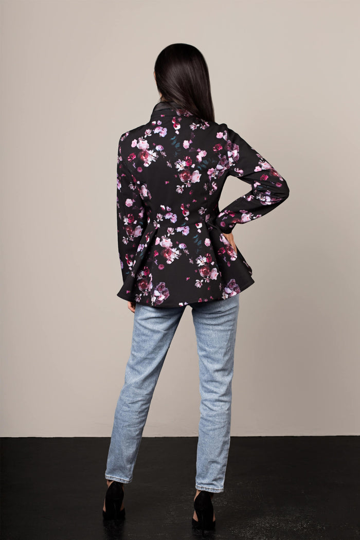 Back view of black floral women's jacket with flared peplum hem and tailored fit